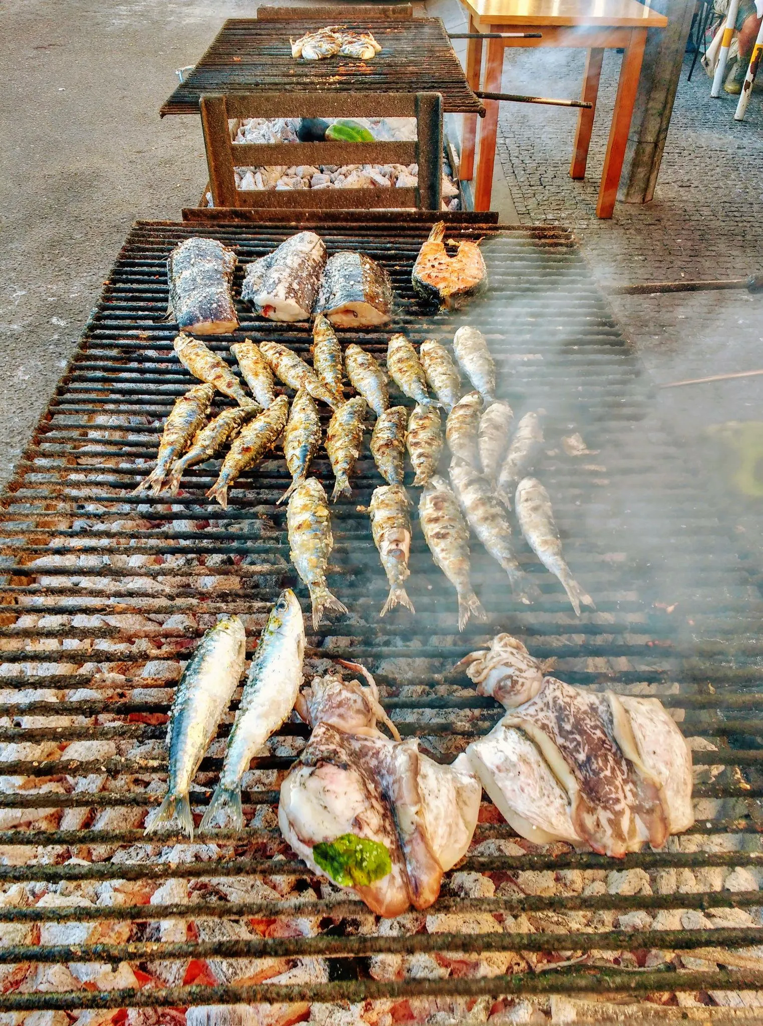 Peixe e sardinhas a grelhar nas brasas, na rua, em Matosinhos