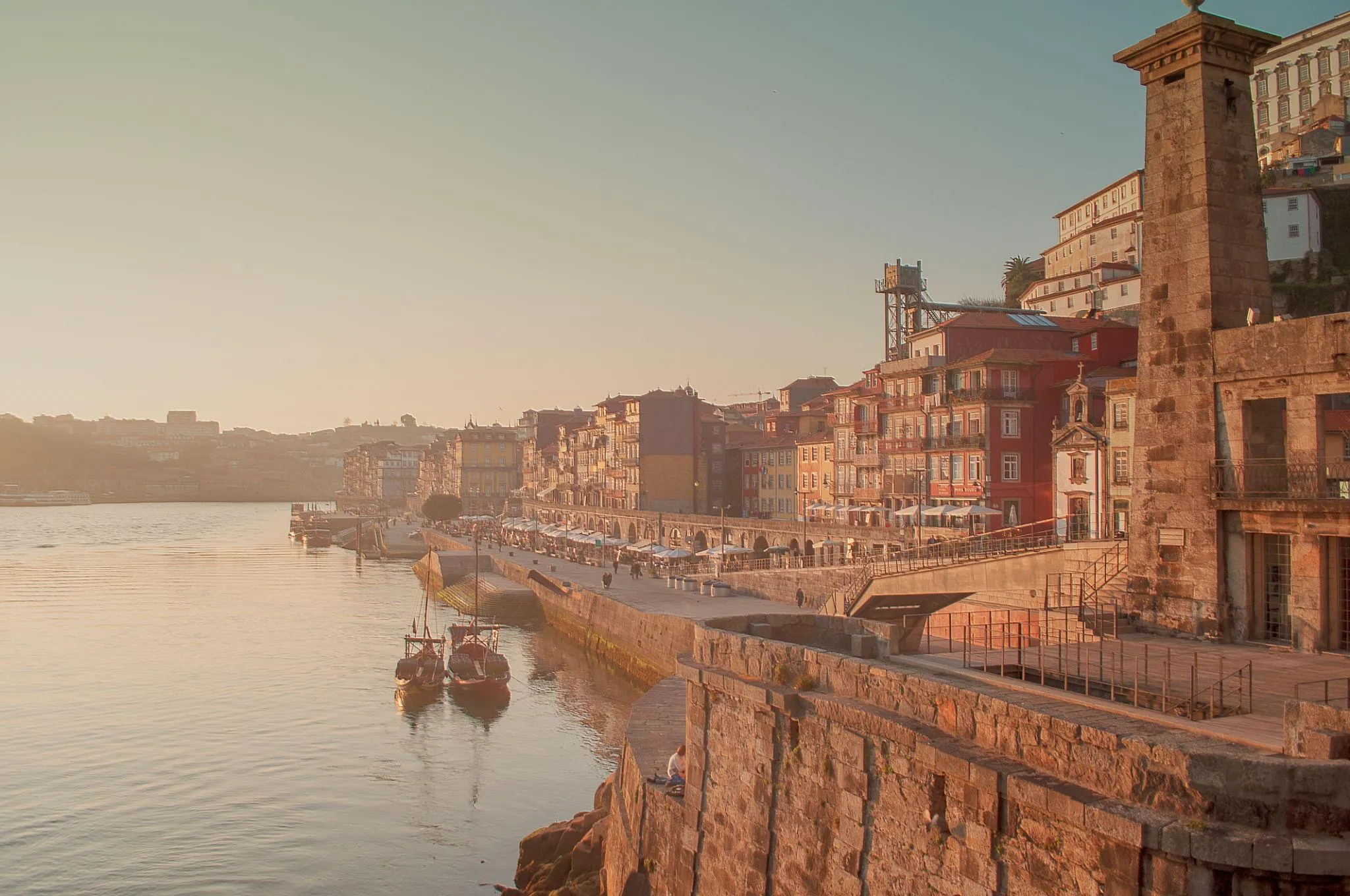 Ribeira do Porto vista de cima, com barcos rabelos e fachadas coloridas ao sol