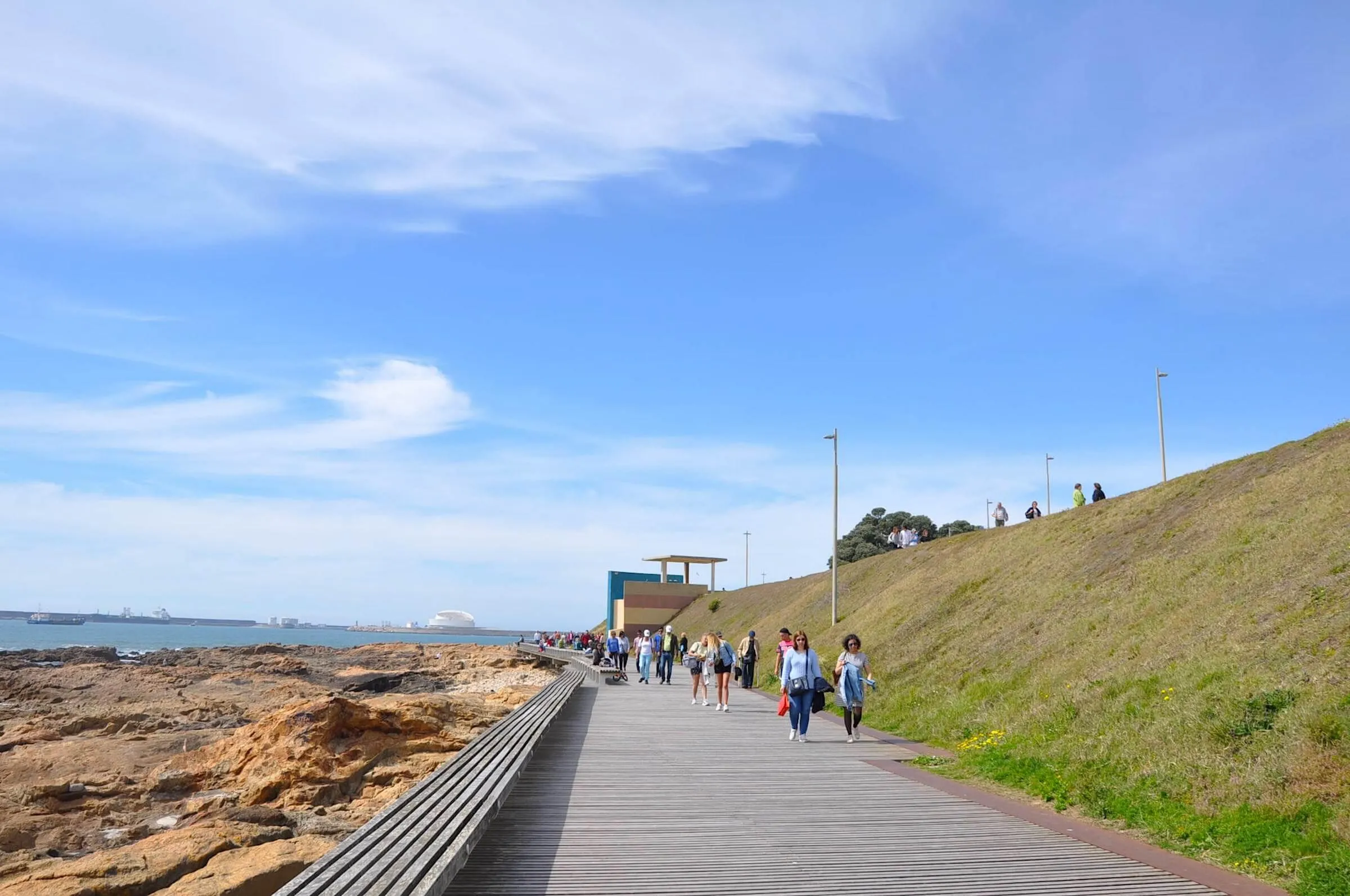 Passeio marítimo entre Foz e Matosinhos, com céu azul e Terminal de Cruzeiros ao longe