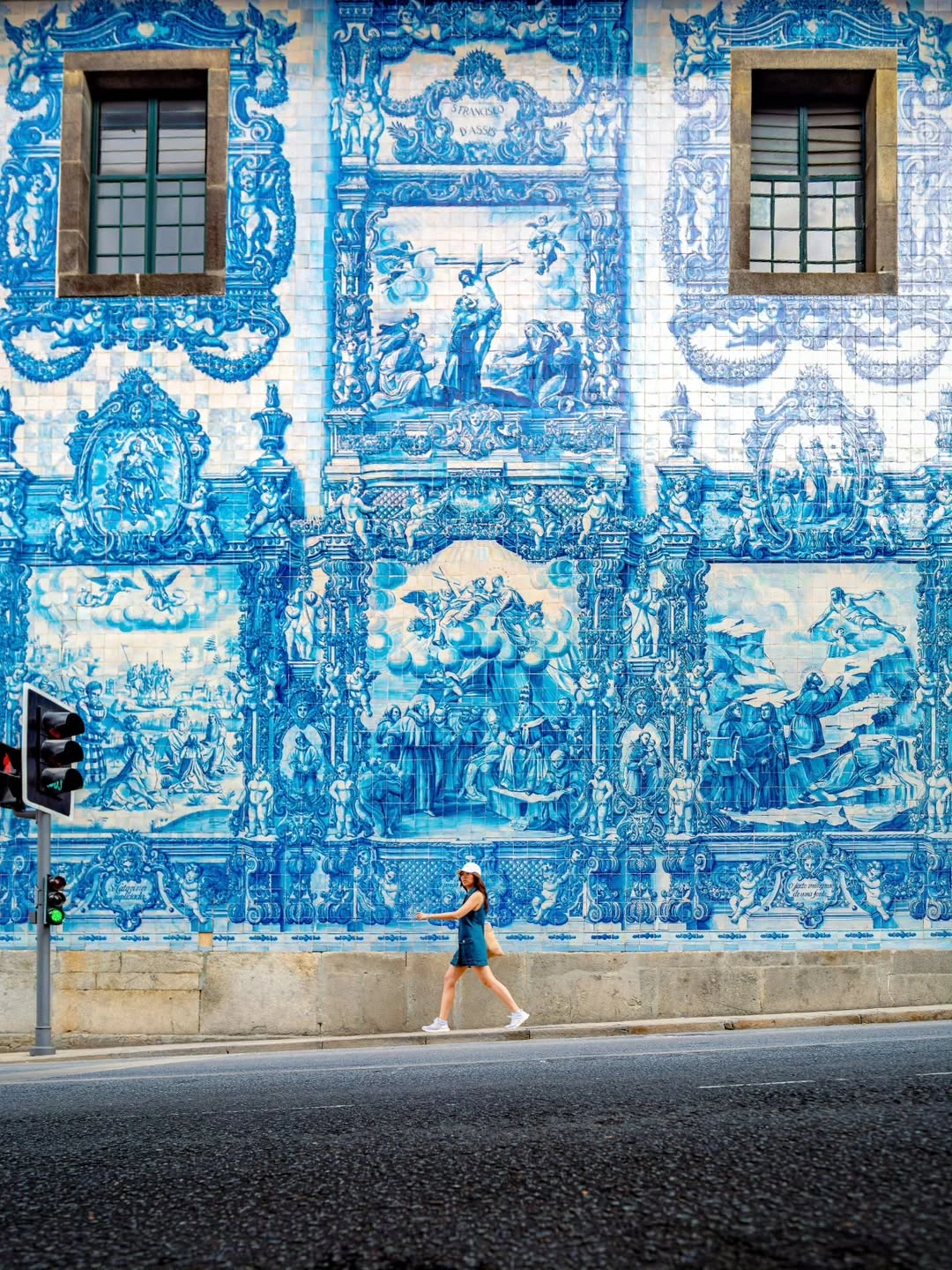 Mulher a passar à frente da fachada azul da Capela das Almas