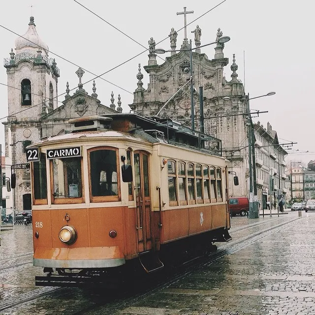 Elétrico amarelo da linha 22 a passar à frente da Igreja do Carmo