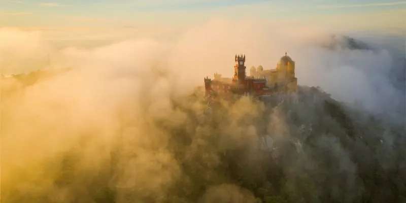 Palácio da Pena visto à distância, sobre a serra ao entardecer