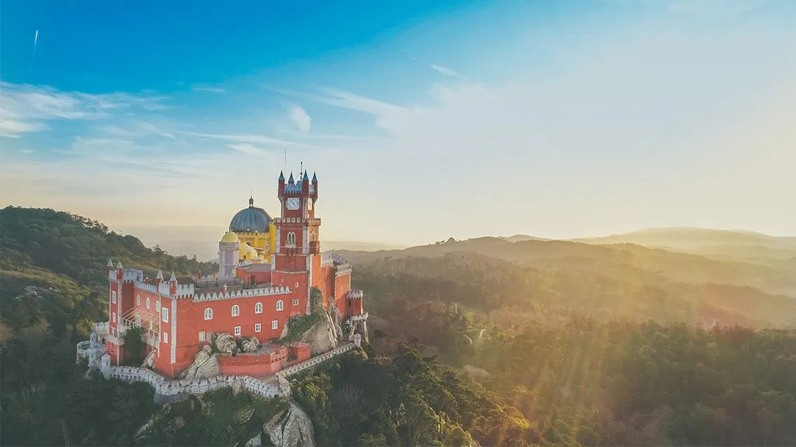 Palácio da Pena envolvido em nevoeiro dourado ao amanhecer